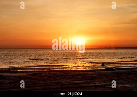 Wunderschöner Sonnenuntergang über dem Meer. Die Sonne geht auf dem Wasser unter. Der Himmel ist mit hellen Farben bemalt. Sommerabend. Sunset Beach. Golf von Finnland, Ostsee Stockfoto