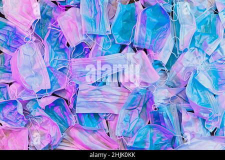 Konzept, gebrauchte medizinische Masken. Stapel von gebrauchter persönlicher Schutzausrüstung. Verschmutzungsmasken während einer Coronavirus-Pandemie. Große Anzahl von medizinischen verwendet Stockfoto