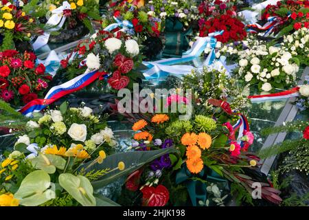 Amsterdam, Niederlande. 30. Januar 2022. Nahaufnahme der farbenfrohen Blumenkränze und Bänder, die das Auschwitz-Denkmal der gebrochenen Spiegel am Nationalen Holocaust-Gedenktag bedecken. Kredit: Steppeland/Alamy Live Nachrichten Stockfoto