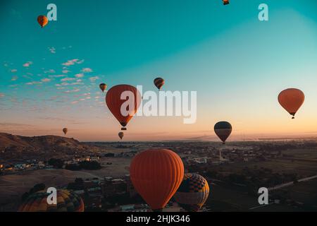 Erstaunlich breite Aufnahme von vielen Ballons, die starten und sich für den Start in luxor ägypten vorbereiten. Toller Blick auf die Umgebung bei Sonnenaufgang Stockfoto