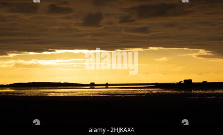 Reise Dänemark: Ein später Winternachmittag am Strand der Insel Rømø mit einem goldenen Himmel, der sich in überfluteten Gebieten widerspiegelt Stockfoto