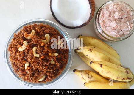 Abgeflachtes Reis, gesüßt mit Zuckerrübe. Aval Vilayichathu ist ein beliebter süßer Snack aus Kerala, der aus geschlagenem Reis, Kokosnuss und Jaggery hergestellt wird. Auf Weiß geschossen Stockfoto