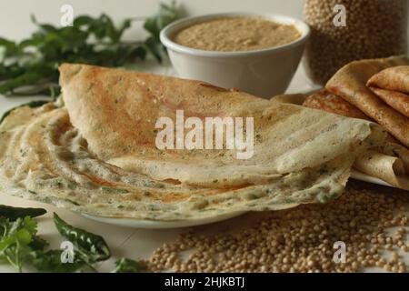 Jowar Dosa. Ein herzhaftes Crepe aus Jowar-Mehl. Goldene knusprige Dosa aus Jowarmehl, Zwiebeln, Kreuzkümmel, Ingwer, grünem Chili und Cor Stockfoto