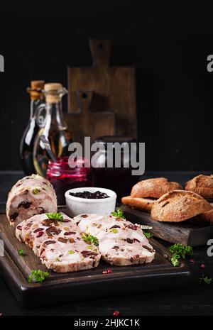 Köstliche Fleischterrine mit Hühnchen in Scheiben, grünen Erbsen und getrockneten Früchten. Hackbraten. Stockfoto