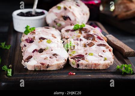 Köstliche Fleischterrine mit Hühnchen in Scheiben, grünen Erbsen und getrockneten Früchten. Hackbraten. Stockfoto