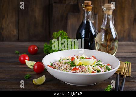 Salat aus Tabbouleh. Traditionelles mittelöstliches oder arabisches Gericht. Levantiner vegetarischer Salat mit Petersilie, Gurke, Couscous, Tomaten. Stockfoto