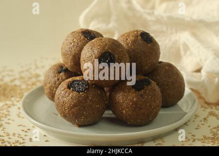 Weiß bis zum Laddu. Ein gesundes, köstliches und nussiges indisches Süßgericht, zubereitet mit weißen Sesamkörnern, Jaggery, frisch geriebener Kokosnuss und Rosinen. Aufnahme Stockfoto