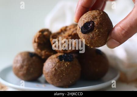 Weiß bis zum Laddu. Ein gesundes, köstliches und nussiges indisches Süßgericht, zubereitet mit weißen Sesamkörnern, Jaggery, frisch geriebener Kokosnuss und Rosinen. Aufnahme Stockfoto