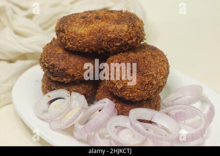 Frittierte Hähnchenschnitzel. Eine flache Krokette aus Hackfleisch, bedeckt mit Semmelbröseln und gebraten. Aufgenommen auf weißem Hintergrund. Stockfoto