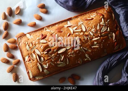 Ghee-Kuchen. Ghee-Kuchen mit Vanillegeschmack und Mandeln darauf. Der perfekte Begleiter für eine Tasse Kaffee. Aufgenommen auf weißem Hintergrund Stockfoto
