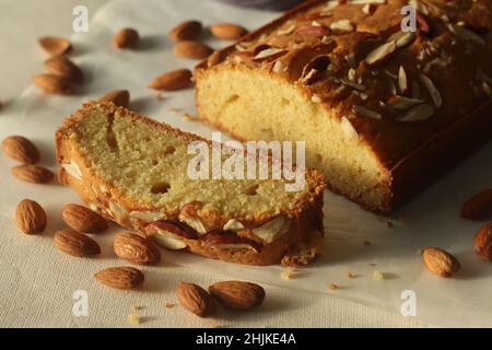 Ghee-Kuchenscheibe. Ghee-Kuchen mit Vanillegeschmack und Mandeln darauf. Der perfekte Begleiter für eine Tasse Kaffee. Aufgenommen auf weißem Hintergrund Stockfoto