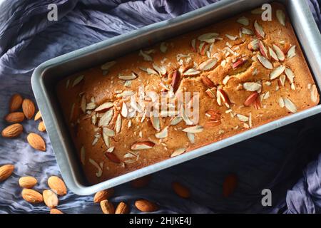 Ghee-Kuchen in der Brotform. Ghee-Kuchen mit Vanillegeschmack und Mandeln darauf. Der perfekte Begleiter für eine Tasse Kaffee. Aufgenommen auf weißem Hintergrund Stockfoto