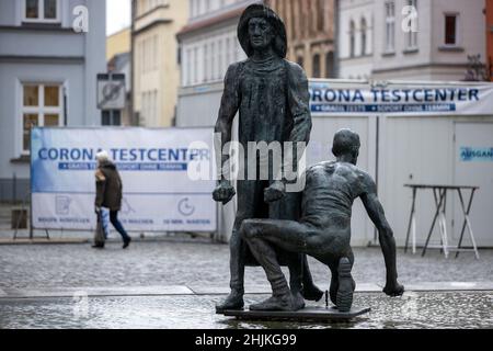 Greifswald, Deutschland. 27th Januar 2022. Eine Frau geht am Corona-Testzentrum hinter dem Fischbrunnen im Stadtzentrum vorbei. In Mecklenburg-Vorpommern treten neue Corona-Relaxationen in Kraft. Neben den Erholungen im Kulturbereich sind nicht mehr nur diejenigen, die gefördert werden, von der Testanforderung ausgenommen. Quelle: Jens Büttner/dpa-Zentralbild/dpa/Alamy Live News Stockfoto