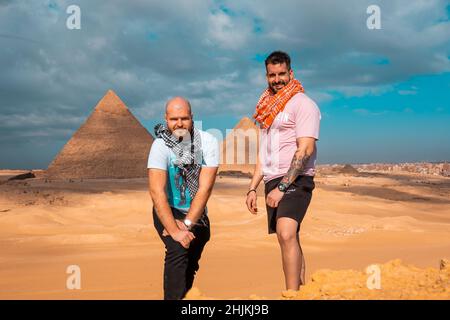 Zwei Männer Reisende posieren vor den großen Pyramiden von gizeh in kairo ägypten. Reisen ägypten im Winter, kalten Winter bedeckt Tag. Stockfoto