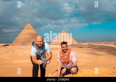 Zwei Männer Reisende posieren vor den großen Pyramiden von gizeh in kairo ägypten. Reisen ägypten im Winter, kalten Winter bedeckt Tag. Stockfoto