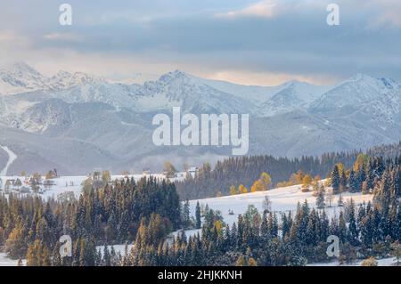 Der erste Schnee in Podhale. Im Hintergrund verschneite Gipfel der Tatra (Swinica, Kasprowy Wierch und Westtatra). Stockfoto