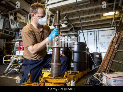 220102-N-HD110-1044 MARINESTÜTZPUNKT GUANTANAMO BAY, KUBA - (JAN 2, 2022) -- Aviation Structural Mechanic 2nd Class Howard Bronson, zugeordnet zu den „Sea Knights“ of Helicopter Sea Combat Squadron (HSC) 22, Detachment 5, reinigt einen Wagenheber an Bord des Freedom-Variant Littoral Combat Ship USS Milwaukee (LCS 5), 2. Januar 2022. Milwaukee wird im Einsatzgebiet der US-Flotte für 4th eingesetzt, um die Mission der Joint InterAgency Task Force South zu unterstützen, die auch Einsätze zur Bekämpfung des illegalen Drogenhandels in der Karibik und im östlichen Pazifik umfasst. Stockfoto