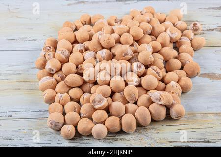 Sojasauce Erdnüsse in einer Holzschüssel. Geröstete Erdnüsse mit Sojasoße überzogen. Gerissene Erdnüsse Mit Sojasoße. Stockfoto