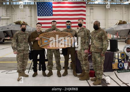 Die Gewinner des vierteljährlichen F-22 Raptor-Lastmannschaftswettbewerbs, Senior Airman Tylor Henderson, Staff Sgt. Andrew Heims und Senior Airman Christian Cortez, die alle die Tafel halten, halten für ein festliches Foto mit Col. Steven Anderson, ganz links, dem Kommandanten der 3rd Maintenance Group, Maj. Timothy Doster, zweiter rechts, dem Kommandanten des 3rd Aircraft Maintenance Squadron und Chief Master Sgt. Horace Abner, ganz rechts, der Flügelwaffenmanager der 3rd Maintenance Group, bei der Joint Base Elmendorf-Richardson, Alaska, 7. Januar 2022. Lastmannschaftswettbewerbe stellen die 3rd Maintenance Group bereit Stockfoto