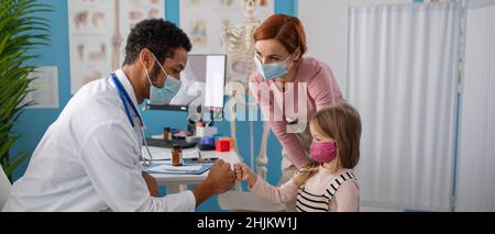 Kleines Mädchen mit ihrer Mutter in der Arztpraxis auf Konsultation, Coronavirus-Konzept. Stockfoto