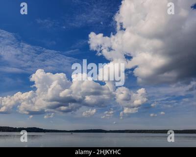 Neblige Meereslandschaft - die ruhige Wasseroberfläche des Sees spiegelt den Fliederhimmel mit rosa und blauen Wolken nach Sonnenuntergang wider. Stockfoto