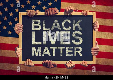 Eine Menge Hand halten ein Banner mit Text SCHWARZE LEBEN MATERIE auf dem Hintergrund der amerikanischen Flagge. Schwarze Leben sind wichtig. Stockfoto