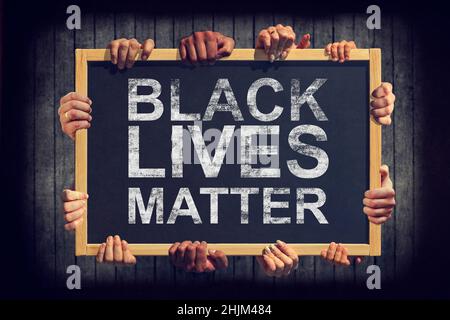 Eine Menge Hand halten ein Banner mit Text SCHWARZE LEBEN MATERIE auf dunklem Hintergrund. Verschiedene Menschen äußern eine gemeinsame Meinung Black Lives Matter. Stockfoto