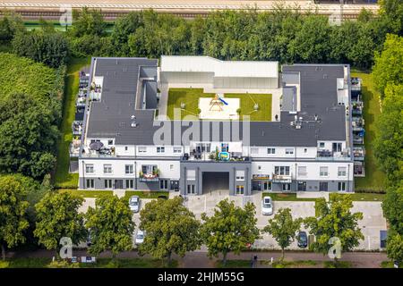 Luftbild, am Bahnhof Holzwickede, neues Wohnhaus und Geschäftshaus in der Bahnhofstraße mit Spielplatz im Innenraum, Freiberg, Holzwickede, Ruhrgebiet Stockfoto