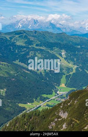 Die Autobahn zwischen den alpen von oben gesehen. Die Berge sind mit Bäumen und Sträuchern bedeckt, und am unteren Rand gibt es eine asphaltierte Straße und weißen li Stockfoto