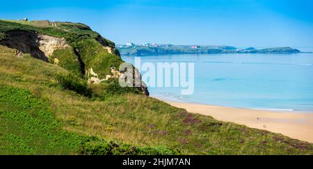 Newquay,Cornwall,England,Vereinigtes Königreich-Juni 21st 2021:Urlauber und Einheimische gleichermaßen, sitzen auf den Klippen und spazieren durch die sandige Bucht unten, genießen die heißen Stockfoto