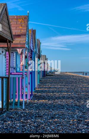 Eine Reihe von traditionellen englischen Strandhütten, gemalt in lebhaften Pastellfarben in Herne Bay, gesehen an einem sonnigen Sonntagmorgen im Januar. Stockfoto
