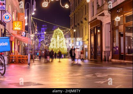 LJUBLJANA, SLOWENIEN - 15. JANUAR 2022: Blick auf die Menschen, die während der weihnachtsfeiertage auf der Straße Copova ulica zum Preserenplatz spazieren Stockfoto