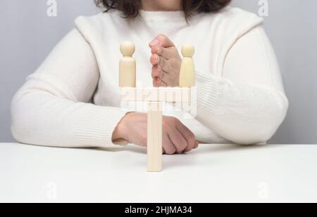 Zwei Holzfiguren eines Mannes stehen einander gegenüber, Konzept der Versöhnung der Gegner, das Ende des Mobbing, die Suche nach einem Kompromiss Stockfoto