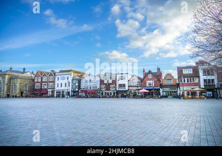 Salisbury England mittelalterlicher Marktplatz im Stadtzentrum mit einer langen Reihe von Geschäften, Bars, Cafés und Restaurants unter einem blau-weißen Wolkenhimmel Stockfoto