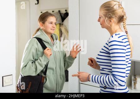 Tochter sagt Auf Wiedersehen Mutter in der Eingangshalle der Wohnung Stockfoto