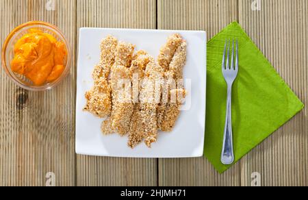 Draufsicht auf Hähnchenfinger in Sesam mit Sauce Stockfoto