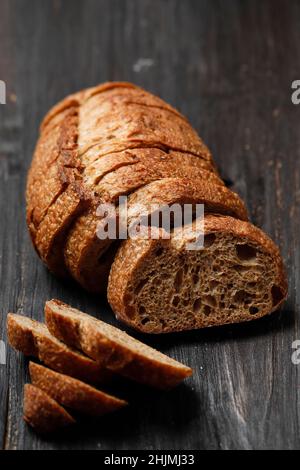 Traditionelles Sauerteig-Brot, auf einem Holzbrett geschnitten, ausgewählter Fokus Stockfoto