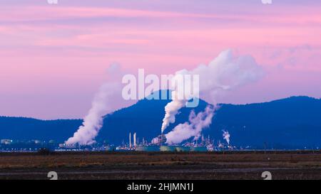 Anacortes, WA, USA - 29. Januar 2022; die Ölraffinerie im US-Bundesstaat Washington gibt im März Dampf aus ihrem Produktionsprozess in den rosafarbenen Himmel ab Stockfoto