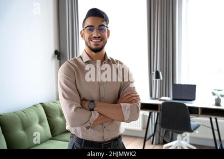 Porträt eines intelligenten indischen Geschäftsmanns, der am Arbeitsplatz im Home Office auf die Kamera schaut Stockfoto