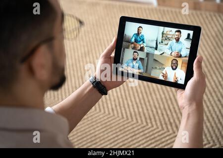 Mann zu Hause mit Online-Meeting virtuelle Konferenz auf digitalem Tablet Stockfoto