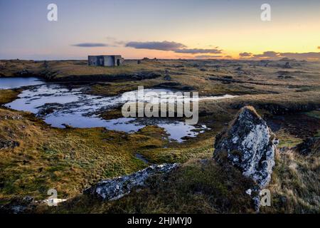 Ein verlassenes Gebäude an der Südküste Islands in der Nähe der Stadt Grindavik bei Sonnenuntergang. Stockfoto