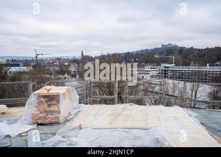 Coburg, Deutschland. 19th Januar 2022. Blick vom Dach des noch im Bau befindlichen Kulturinstituts Globe in Richtung Coburger Veste. Die Bauarbeiten am Theater Globe in Coburg gehen voran. Das runde Gebäude aus Fichte soll im Frühjahr 2023 für die Öffentlichkeit zugänglich sein. Das Gebäude im britischen Stil wird als alternativer Veranstaltungsort für das Landestheater dienen. Quelle: Nicolas Armer/dpa/Alamy Live News Stockfoto