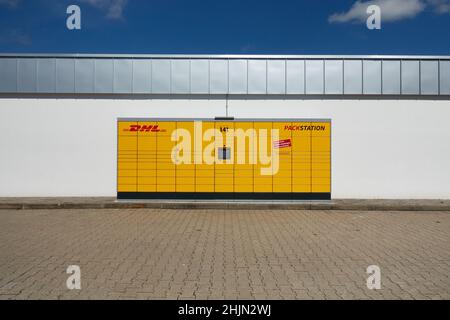 Neckartenzlingen, Deutschland - 29. Juni 2021: DHL Paketautomat auch Packstation. Gelbe Maschine zum Senden und Empfangen von Paketen. In einem weißen Gebäude Stockfoto