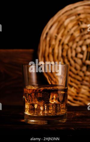 Gekühlter Whiskey mit Eiswürfeln auf Holzhintergrund im Keller Stockfoto