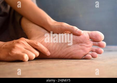 Fuß des asiatischen jungen Mannes. Konzept der Fußpflege und Gesundheit. Stockfoto