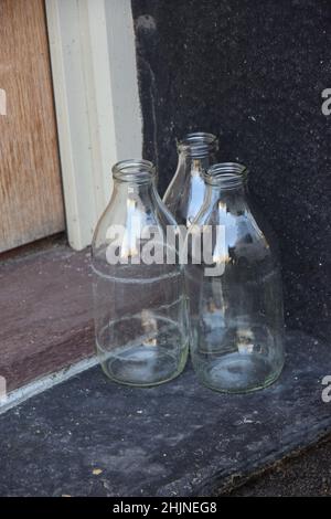Leere Milchflaschen warten auf die Abholung durch Milkman, suffolk, england Stockfoto