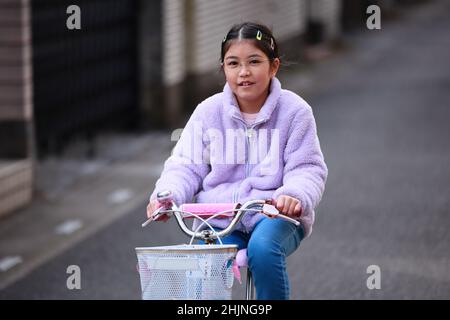 Selbstbewusst durch die Nachbarschaft navigieren! Jede Straße ist ein neuer Weg, den man mit meinem treuen rosa Fahrrad erkunden kann. Stockfoto