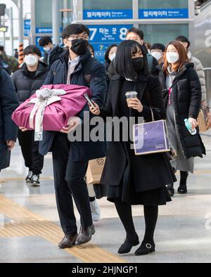 Seoul, Südkorea. 31st Januar 2022. Menschen mit Gesichtsmasken bereiten sich darauf vor, am Bahnhof Seoul in Seoul, Südkorea, an Bord ihres Zuges zu gehen, 31. Januar 2022. Viele Südkoreaner entscheiden sich immer noch für Reisen nach Hause während des traditionellen Neujahrsfestes, der vom 29. Januar bis zum 2. Februar dieses Jahres dauert, obwohl die Regierung die Menschen aufgefordert hat, während der COVID-19-Pandemie zu Hause zu bleiben. Kredit: Seo Yu-Seok/Xinhua/Alamy Live Nachrichten Stockfoto