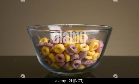 Nahaufnahme von bunten Flocken. Archivmaterial. Köstliche süße Ringe in verschiedenen Farben auf isoliertem Hintergrund gemalt. Süße Flocken in Form von mult Stockfoto