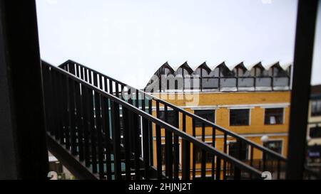 Feuerflucht in der dunklen Gasse. Filmmaterial. Typische Nottreppe vom alten Gebäude. Notausflucht. Stockfoto